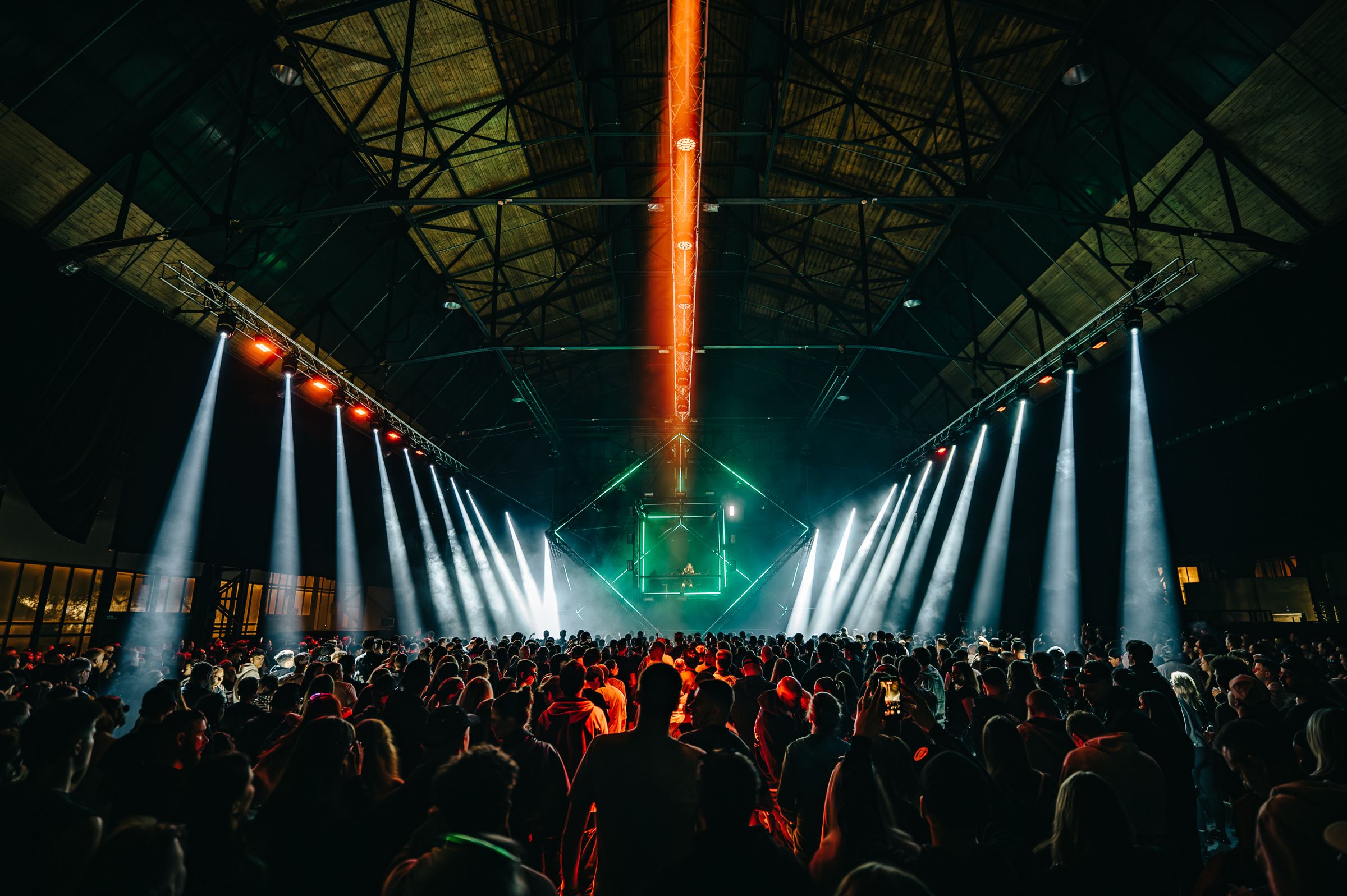 Light beams above a packed industrial hall