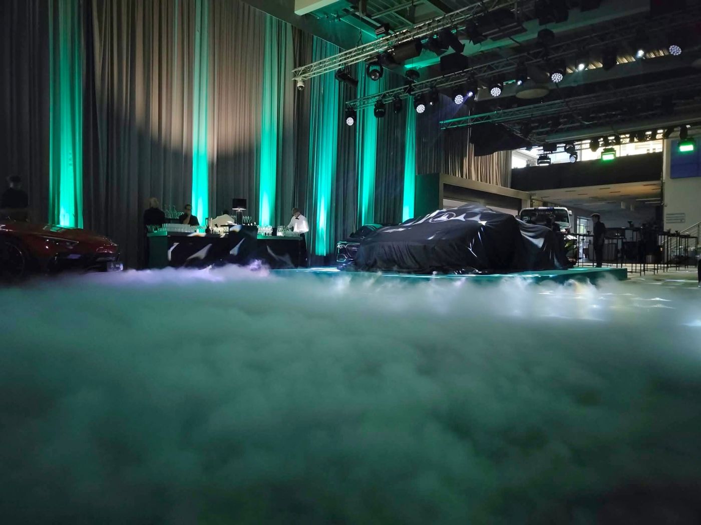 Covered car in a lit showroom with haze